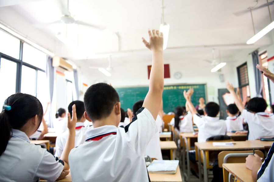 Students raising their hands in an English class in China