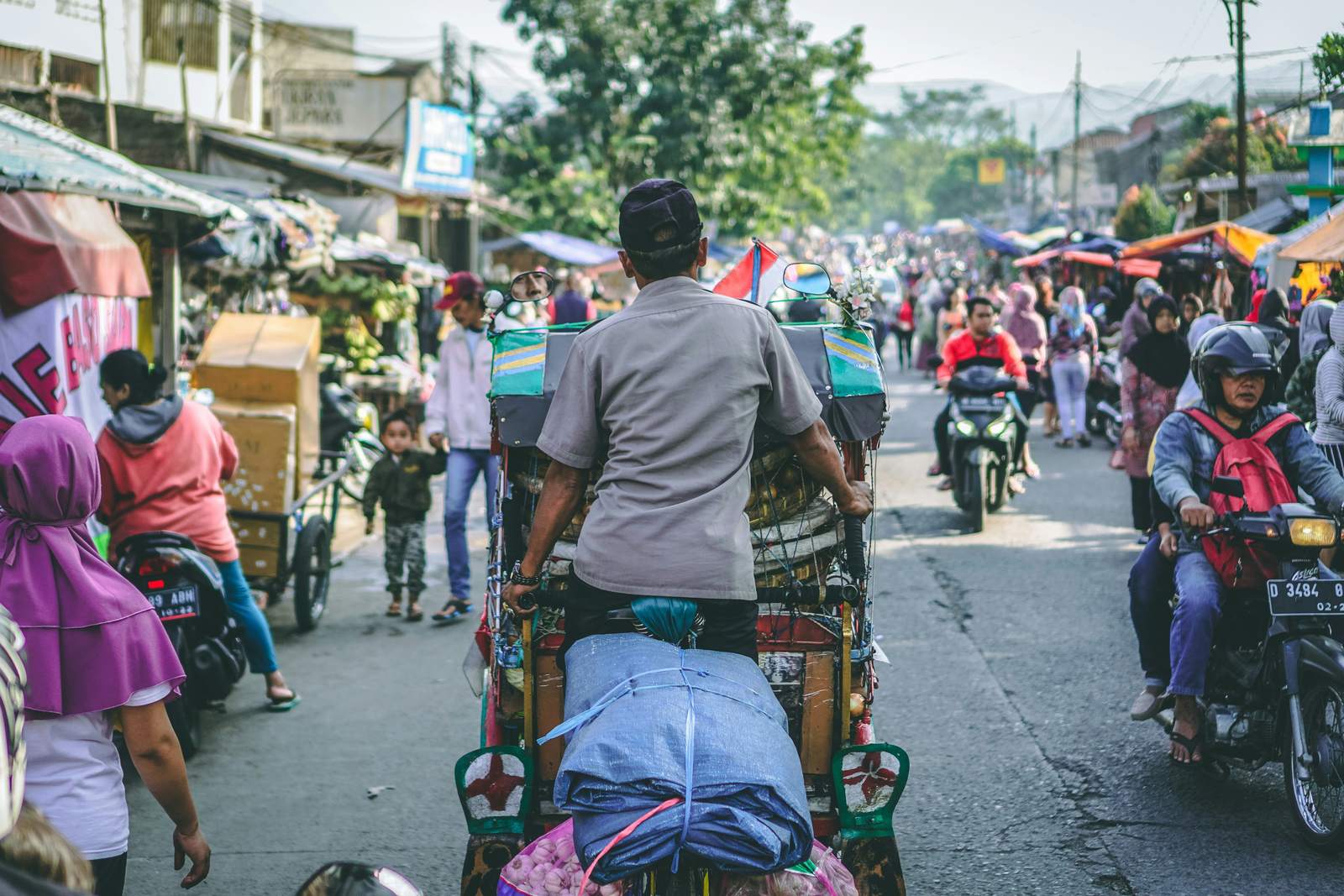 Busy street market with a becak cycle rickshaw in Indonesia