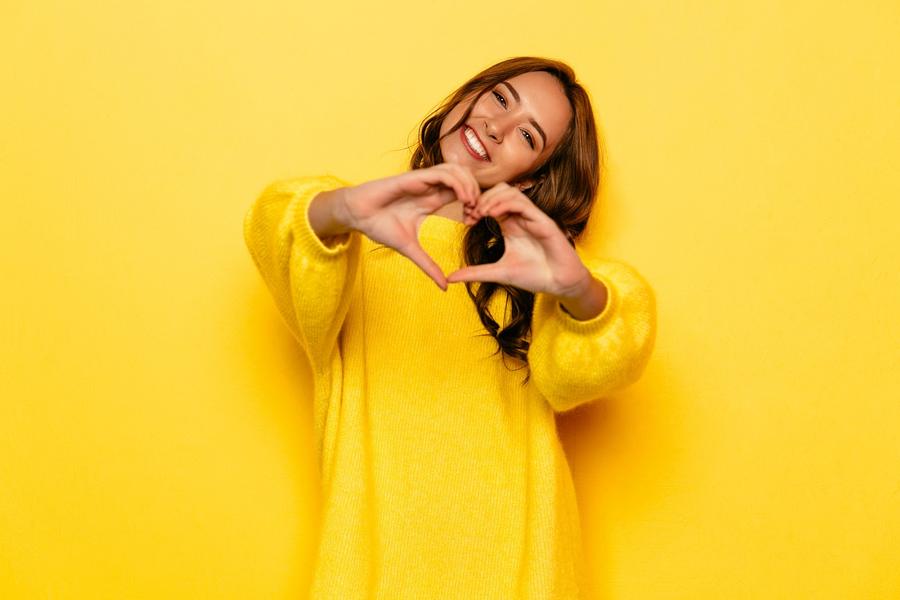 Happy teacher making a heart shape with her hands