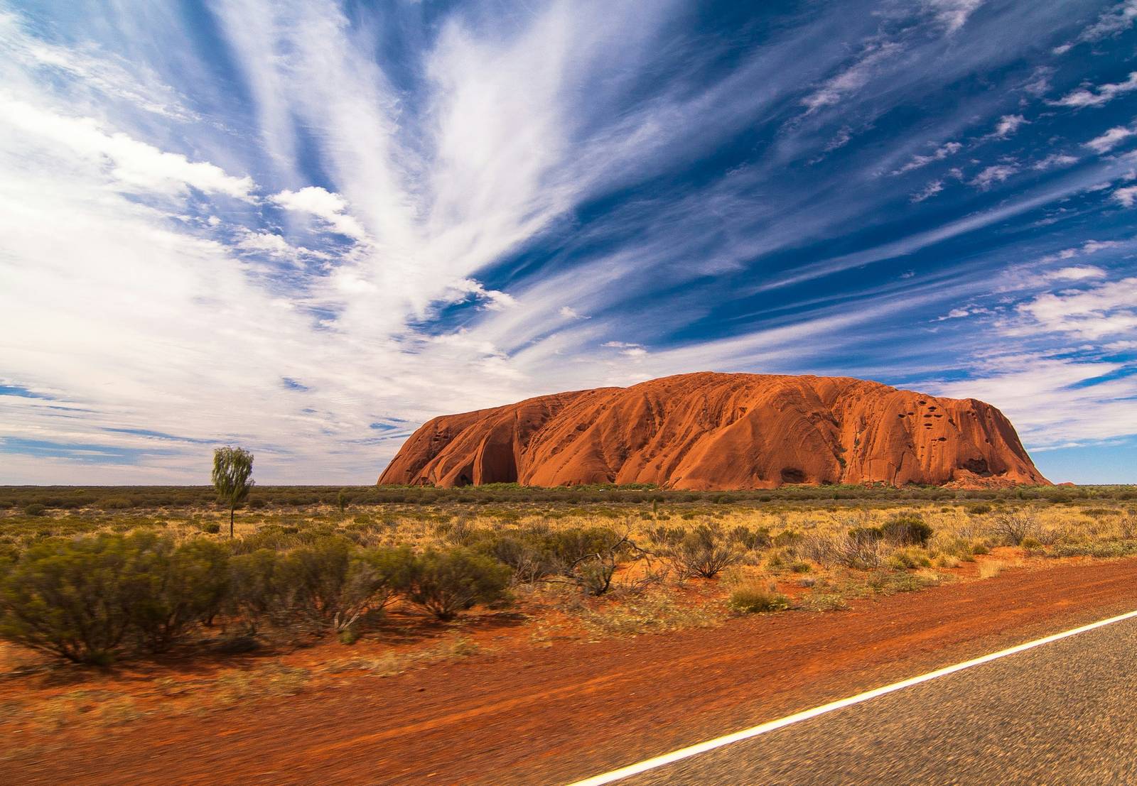 Uluru in the Australian outback under a blue sky